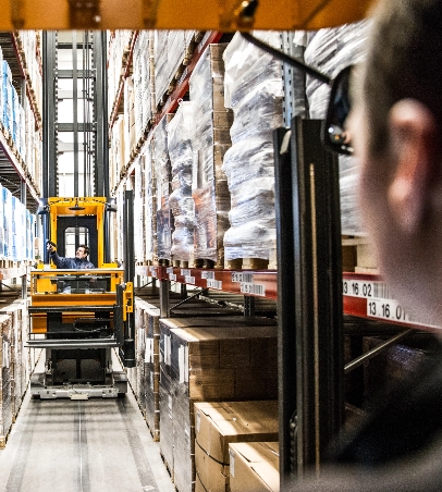 Employee driving a forklift around a warehouse